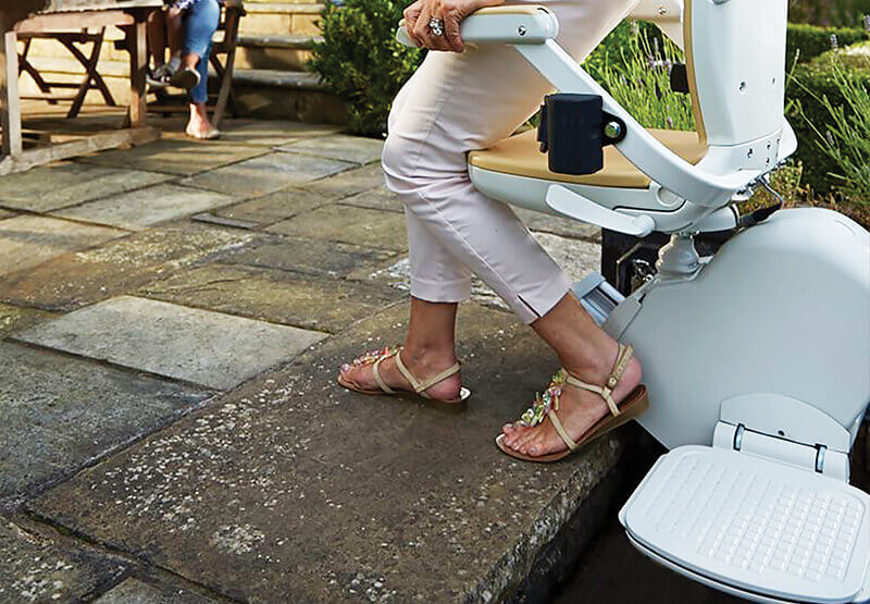 lady stepping off outdoor stairlift