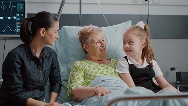 daughter and grandchild watching grandma recover from surgery